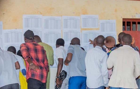 Candidats consultant des listes de résultats affichées en Guinée