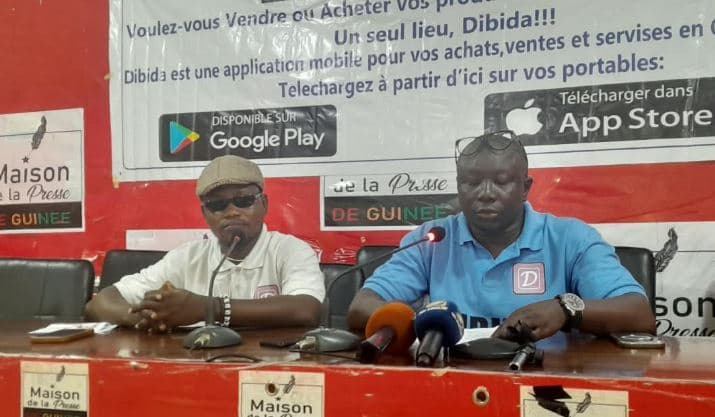 Deux responsables de Dibida présentent l’application lors d’une conférence de presse à Conakry