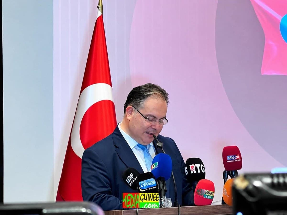 L’ambassadeur de Türkiye en Guinée, Cem Örnekol, prenant la parole à Conakry devant le drapeau turc